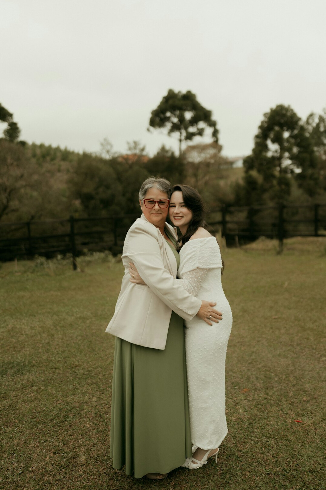 Adult daughter and senior mother smiling together outdoors